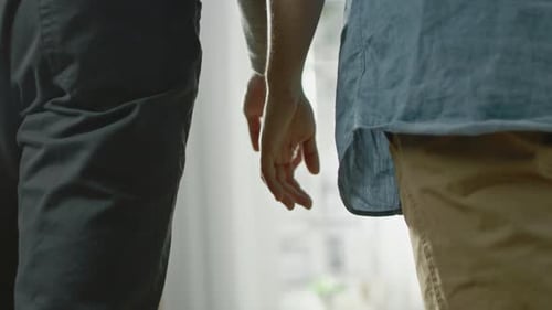 Close Up of Two Male Hands Gently Touching and Holding Each Other. Cute Queer Relationship Concept.