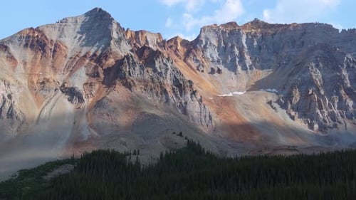 Sunlit ridges and steep rock faces across the San Juan Mountains, aerial