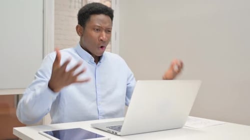 African Businessman Shocked by Loss on Laptop in Office