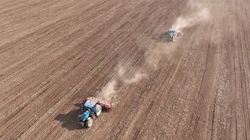 Tractors Planting Crops in Rural Field, Aerial Shot