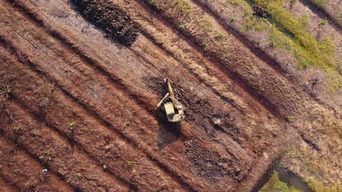 Aerial view of a wheel loader excavator with a backhoe loading sand into a heavy earthmover