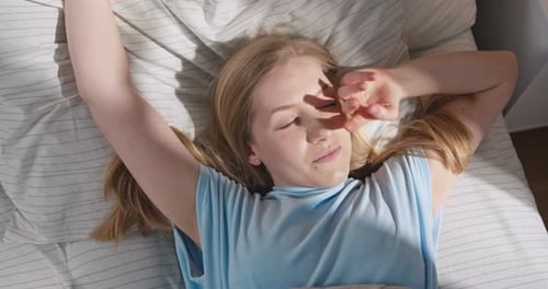 Woman Waking up in Bed Smiling