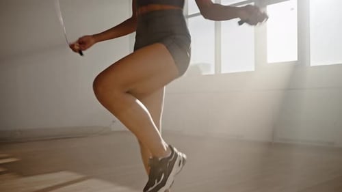 Junge Sportlerin beim Seilspringen während eines Cardio-Trainings von unten nach oben auf einer Steadicam gefilmt