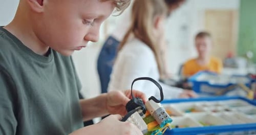 Boy Assembling Robot in Classroom Technology Project