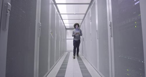 Technician with Tablet Walking in Server Room