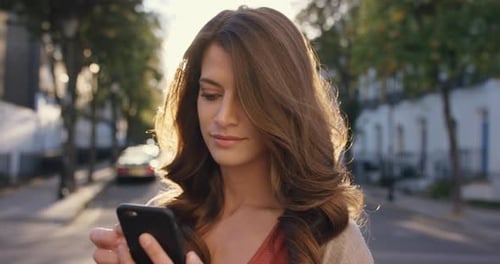 4k video footage of a woman using her cellphone while out in the city