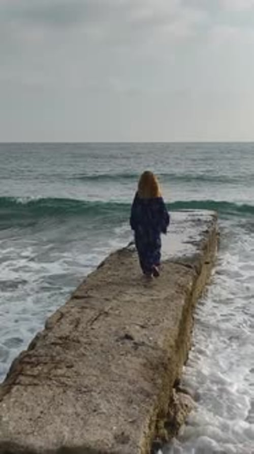 Vertical Video Elegant Model on a Pier Enjoying the Calm and Beauty of the Mediterranean