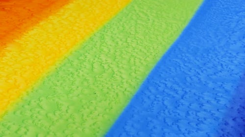 Close-up view of striped fabric hand-dyed in rainbow colors. Color gradients and textile texture