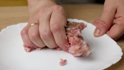 Dem 1. Hackfleisch werden Pfeffer und Gewürze zugesetzt. Zubereitung von Gerichten aus Hackfleisch.