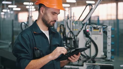 Machinery conception, operator is with tablet. Man is working in the modern factory.
