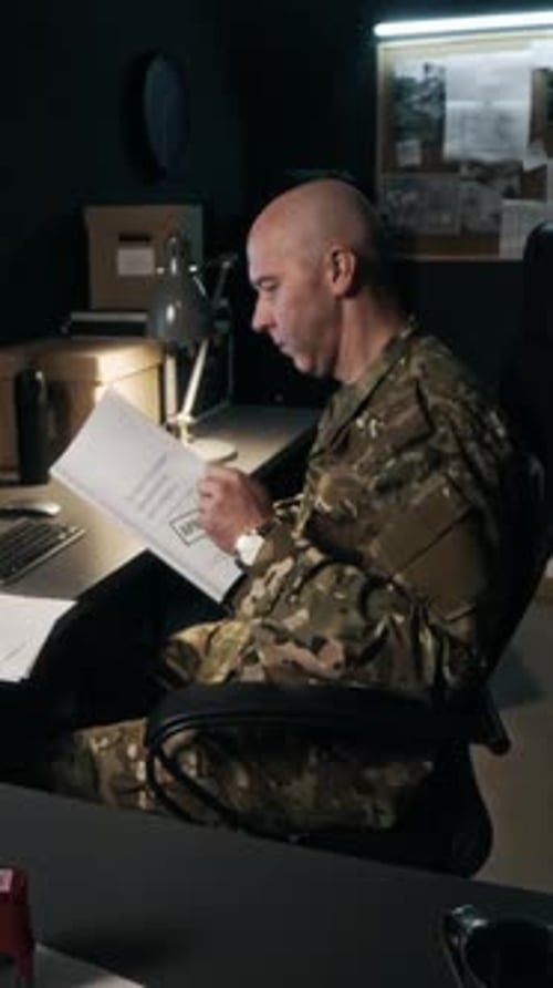 Officer Answering Phone while Doing Paperwork in Command Center