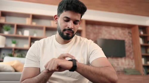 Arabic Man Setting Heartrate Watch During Home Training