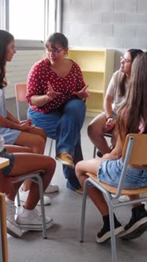 Diverse Happy Group of Primary School Students Sitting on Chairs in Circle Interacting During Lesson