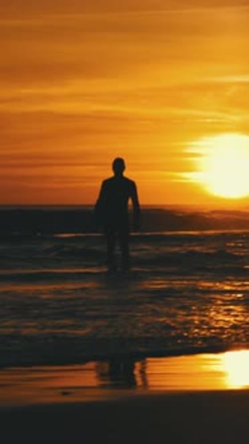 Man Silhouette Standing in the Ocean at Sunset
