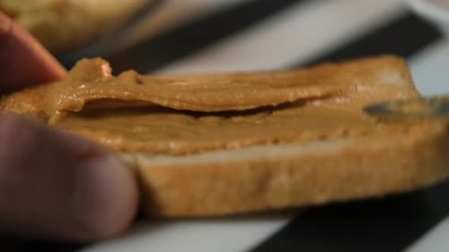 Spreading Peanut Butter on Toast for Breakfast Snack