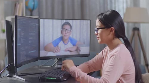 Asian Teen Girl Programmer Waving Hand Having Video Conference On Desktop Computer
