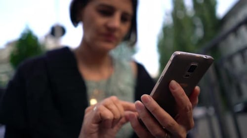 Femme envoyant des SMS au téléphone en ville