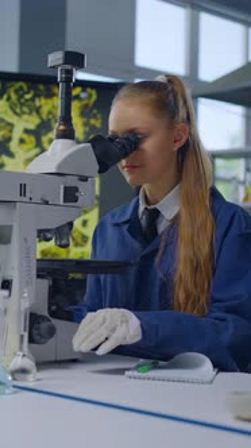 Young Woman Scientist Using Microscope in Laboratory Setting