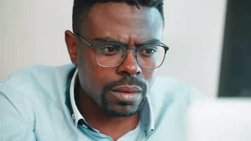 Man Works on Laptop in Home Office