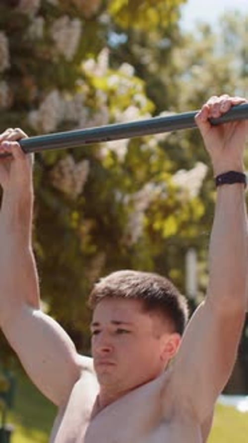 Homme musclé aux seins nus athlétique du Caucase faisant des exercices de tractions sur une barre horizontale pour pomper le dos