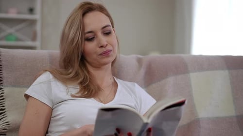 A Relaxing Woman Engaged in Reading a Book at Her Cozy Home Setting and Environment