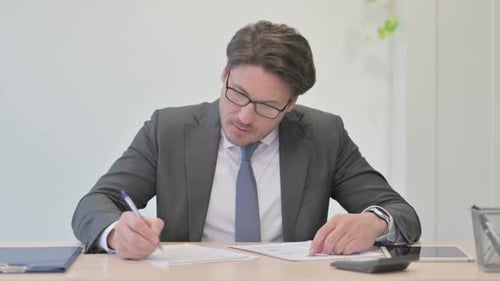 Serious Adult Reviews Documents in Office