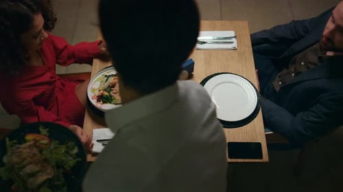 Waiter Serving Italian Dinner to Couple on Restaurant Table. Unknown Kitchen Chef