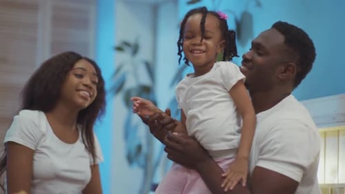 Happy family with young girl on bed smiling
