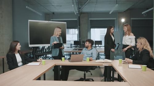 Colleagues discuss project plans in a modern office space during a team meeting