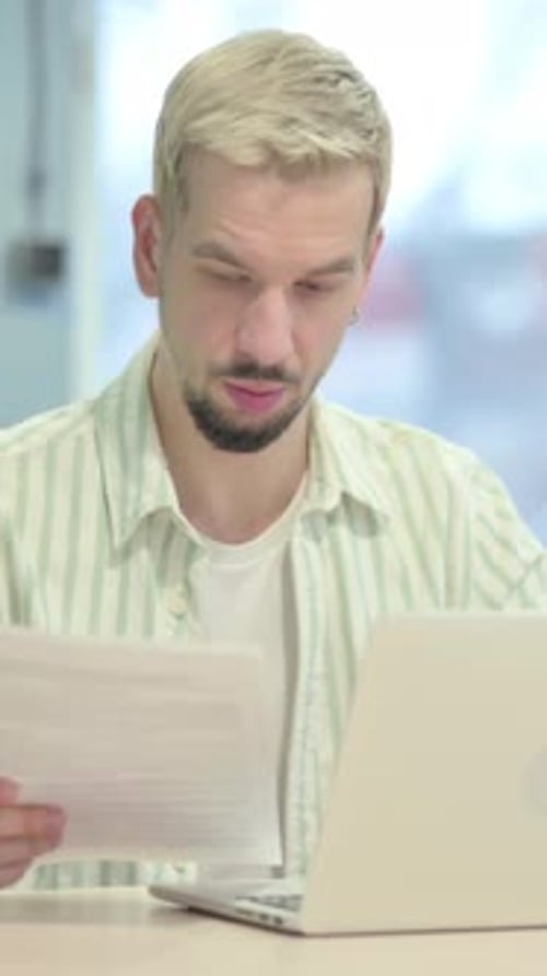 Young Man Doing Paperwork in Office