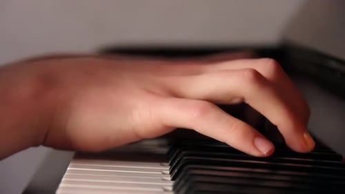 Hand Plays Piano Keyboard in Close Up