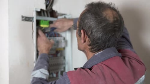 Electrician Repairing Electrical Panel Inside a Home
