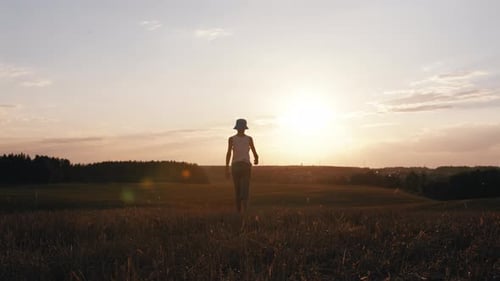 Boy's Journey at Sunset Walking Through a Field