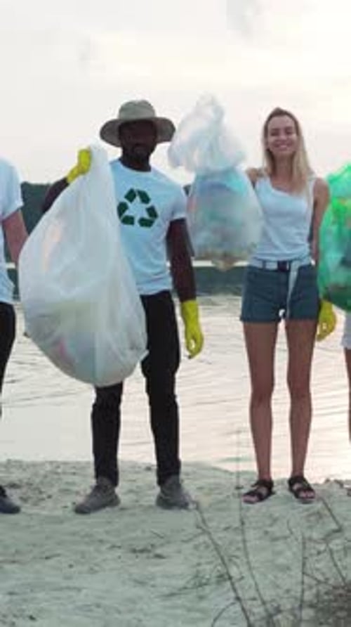 Group Holding Trash Bags on a Beach