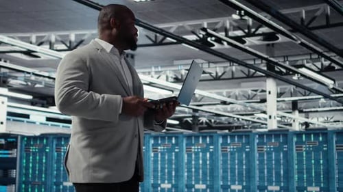 Admin Walking in Data Center Industrial Platform Analyzing Performance