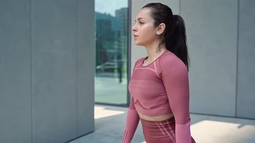 Woman Doing Squats Outdoors in Urban Setting