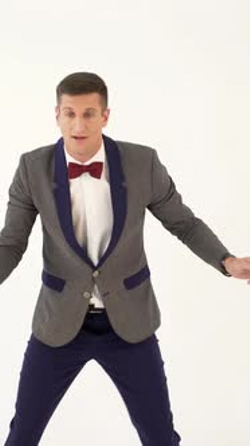 fun showman in trendy costume is parodying a man playing table tennis