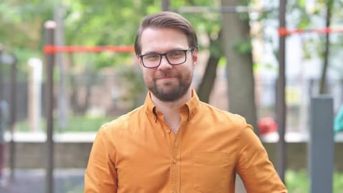 Man Gesturing to Camera Outdoors