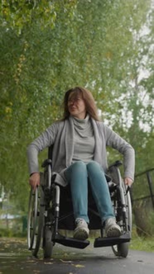Young Person in Wheelchair Spends Free Time in Green Park