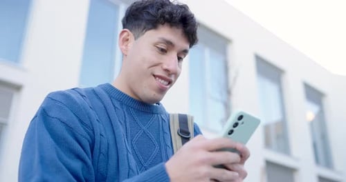Man Smiles While Reading on Mobile Phone