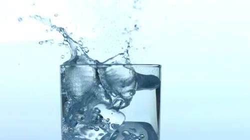 Ice Cubes Dropping into a Glass of Water