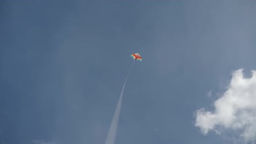 A Vibrant Kite Glides Effortlessly in the Open Sky Creating a Peaceful Uplifting Scene