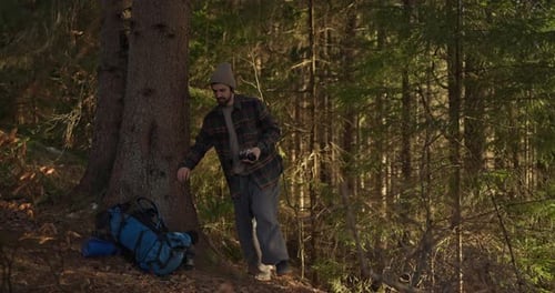 Man Relaxing with Backpack in Forest