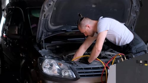 A Car Repairman Checks the Air Conditioner in a Car