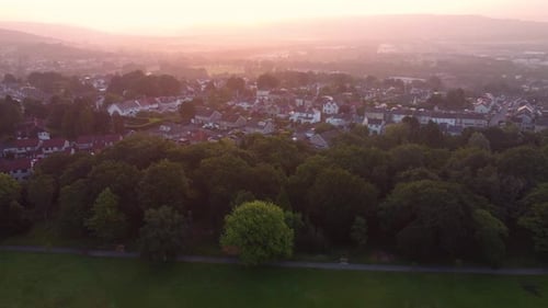 Pushing Aerial Towards Houses at Dawn with Hazy Sunrise Covering Valley with Nearby Park with Trees