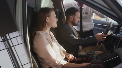 Couple Sitting Inside Car Together with Woman Smiling