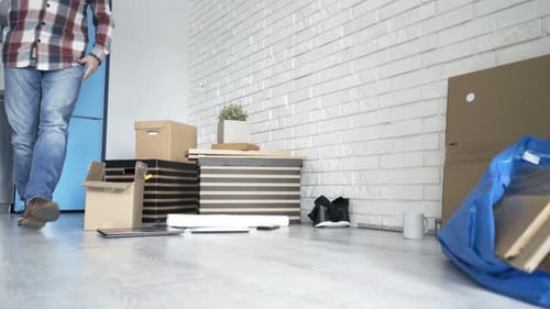 Man Exhausted from Moving Sits on Apartment Floor