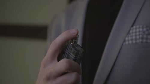 Close up of person using fragrance bottle