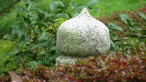 Stone lantern among shrubs in a Japanese garden.