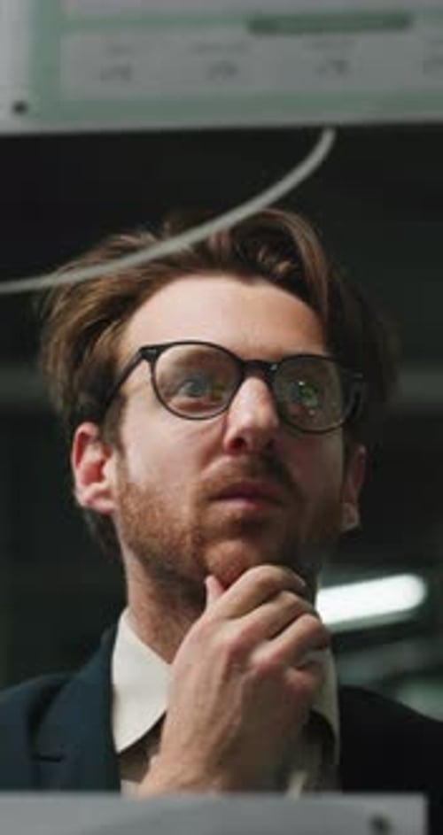 Contemplative Man with Glasses in an Office Setting